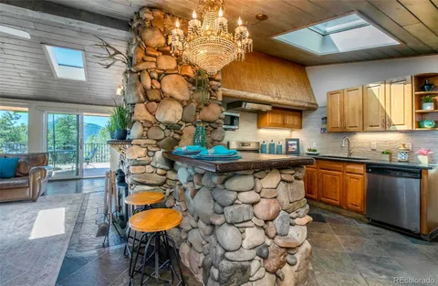 a kitchen with stainless steel appliances granite countertop a sink a stove and a wooden cabinets