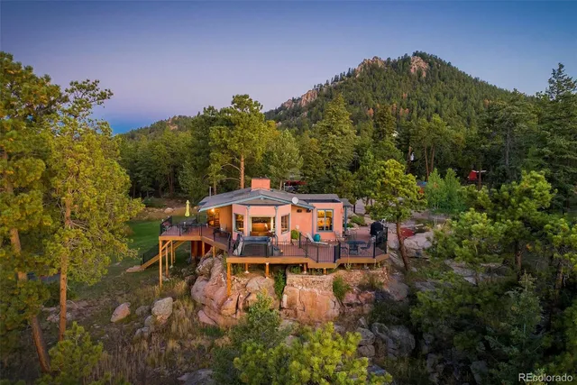 a aerial view of a house with a yard lake and mountain view