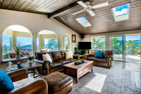 a living room with furniture fireplace and a large window
