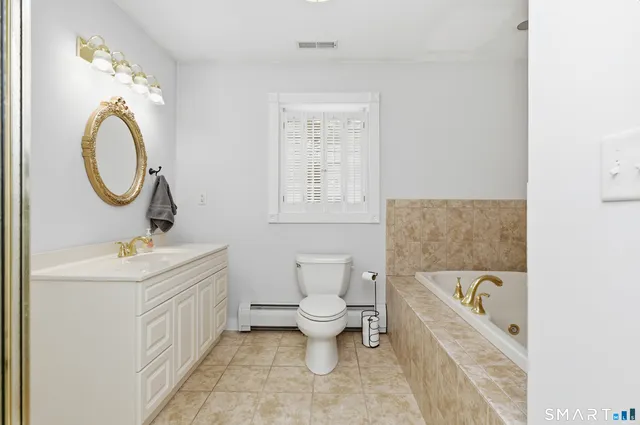 a bathroom with a bathtub sink mirror and toilet