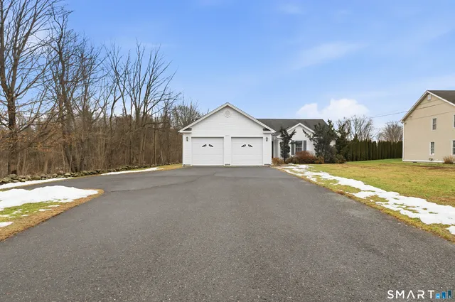 a view of a house with snow on the road and yard
