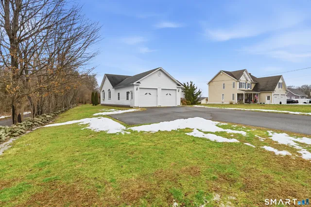 a view of a big house with a big yard and large trees