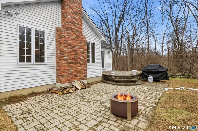 a backyard of a house with fire pit and barbeque oven