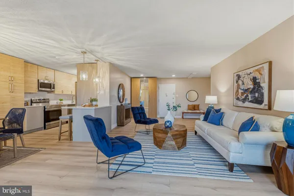 a living room with furniture kitchen view and a large window