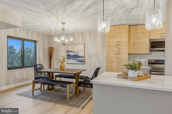 a living room with a table chairs and a chandelier