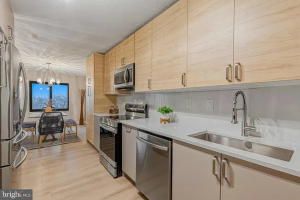 a kitchen with stainless steel appliances a sink dishwasher stove and refrigerator