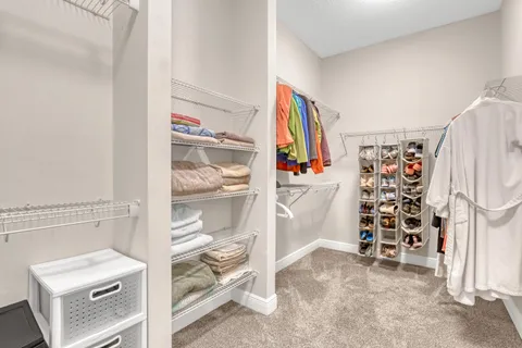 a view of walk in closet with clothes and shoes
