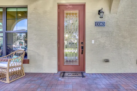 a view of a hallway with wooden floor and a bathroom
