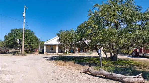 a front view of a house with a yard and potted plants