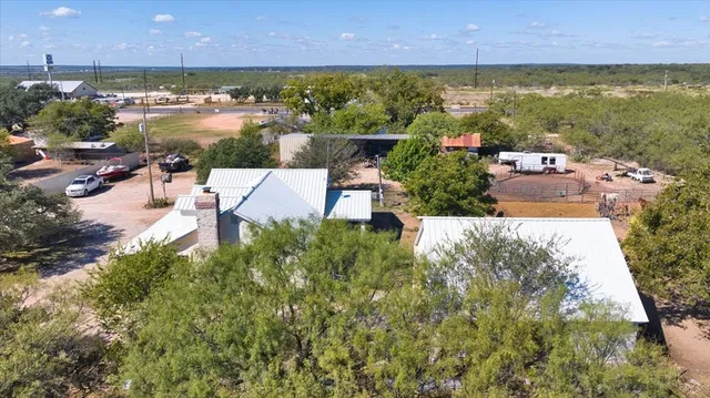 an aerial view of ocean and residential houses with outdoor space