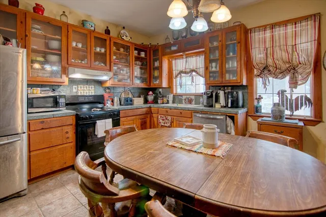 a kitchen with stainless steel appliances granite countertop a stove a sink dishwasher and cabinets with wooden floor