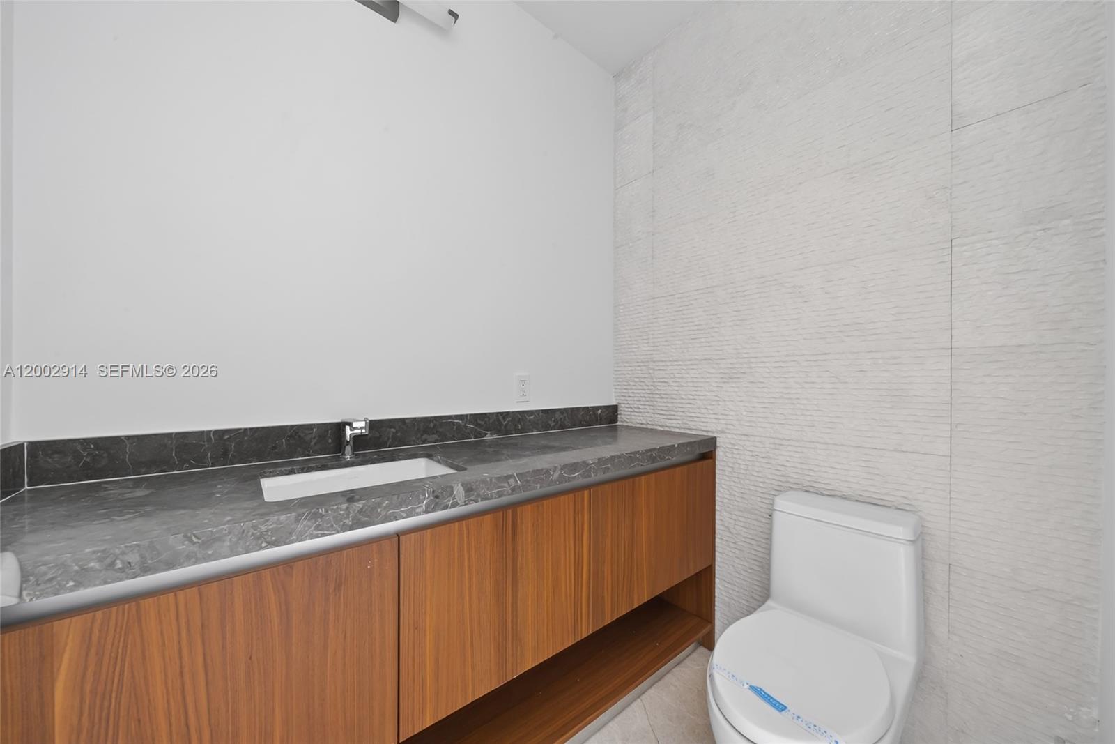 175 Southeast 25th Road, Unit 2602 Miami, FL 33129 - Photo 31 of 74 a bathroom with a granite countertop toilet and a sink