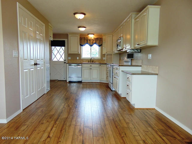 11301 Zier Road Yakima, WA 98908 - Photo 3 of 14 a kitchen with stainless steel appliances wooden floors and view living room