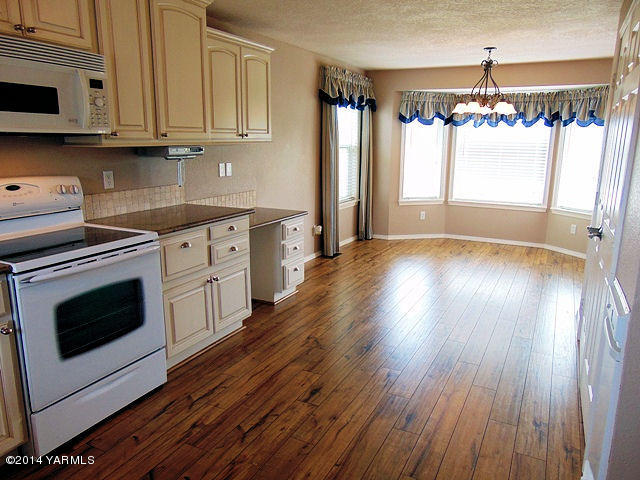 11301 Zier Road Yakima, WA 98908 - Photo 4 of 14 a kitchen with granite countertop wooden floors stainless steel appliances and sink