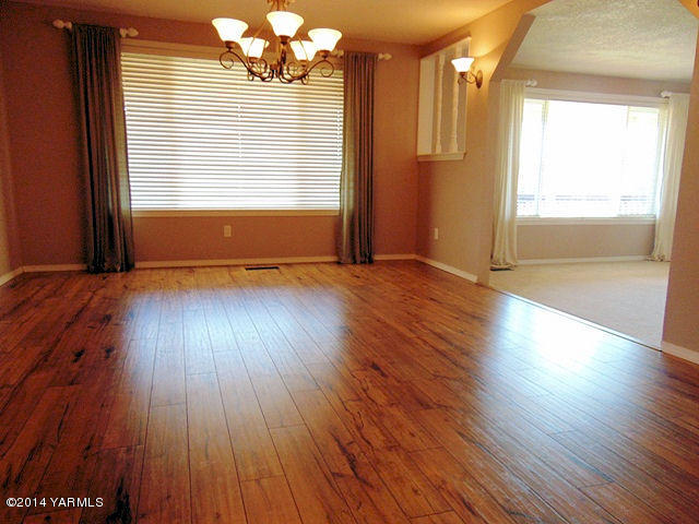 11301 Zier Road Yakima, WA 98908 - Photo 6 of 14 an empty room with wooden floor and windows