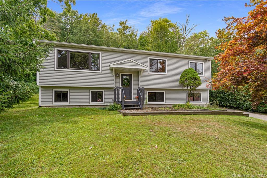 203 Hanover Road Newtown, CT 06470 - Photo 1 of 1 a front view of house with yard and trees in the background