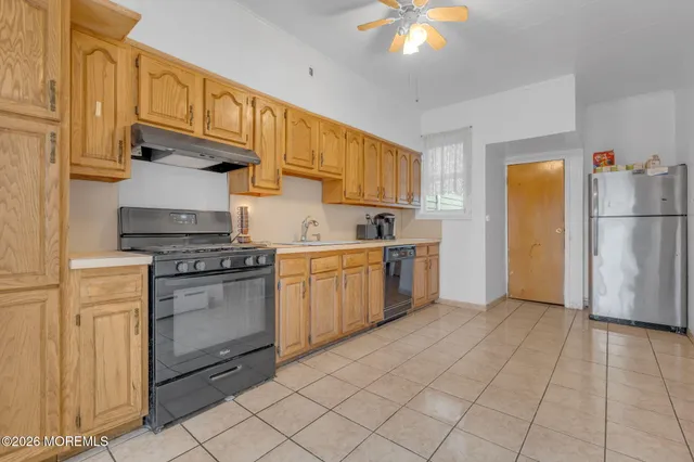 a kitchen with a refrigerator a stove top oven and cabinets