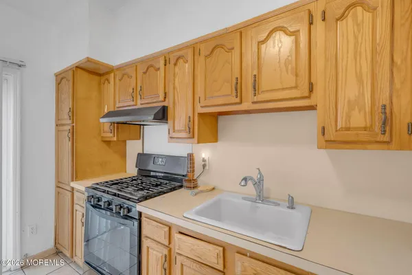 a kitchen with granite countertop a sink stove and cabinets