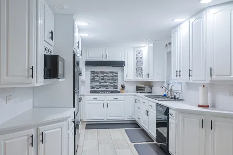 a kitchen with a white cabinets and chairs