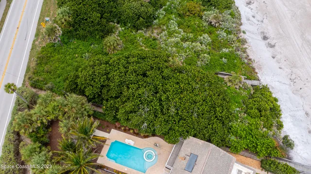 an aerial view of a house with a yard and lake view