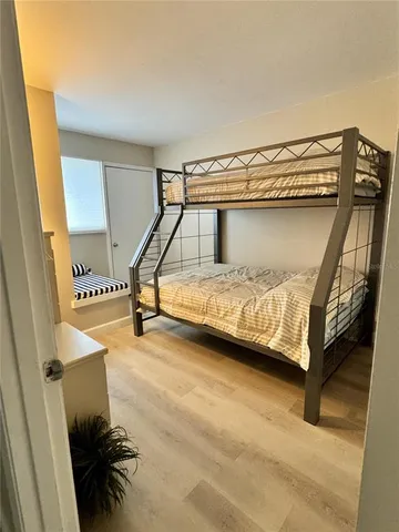 a bedroom with a bed and wooden floor