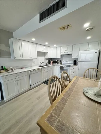 a kitchen with sink refrigerator and cabinets