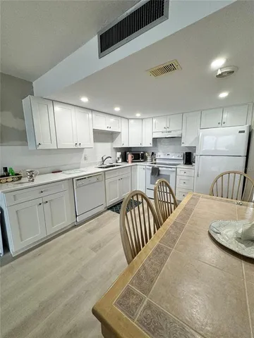a kitchen with sink refrigerator and cabinets