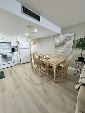 a dining room with furniture and a kitchen view