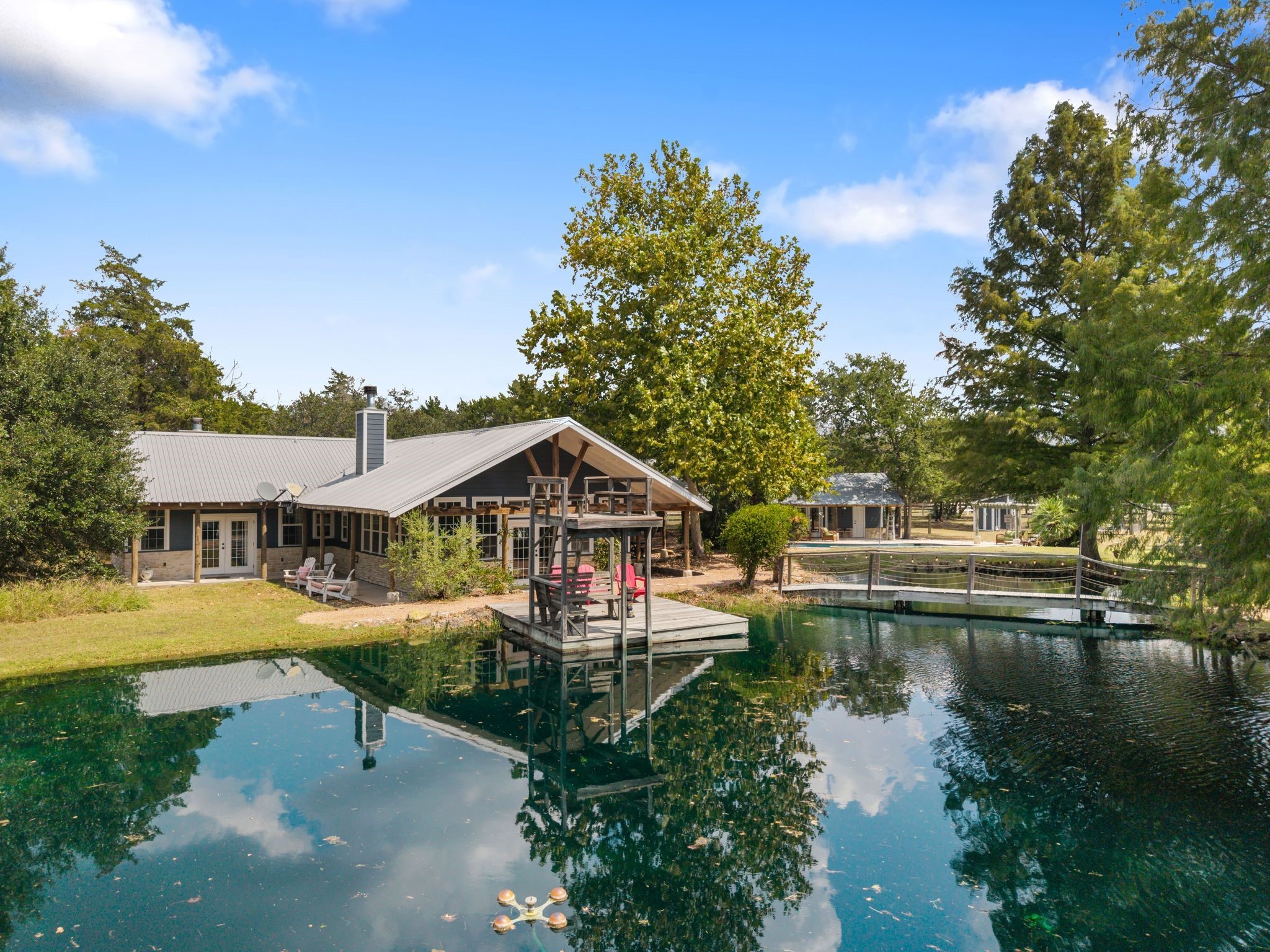 Private Round Top retreat on 8.7 acres featuring a main home, guest house, sparkling pool with pool house, and a stocked pond with dock and piers. Just minutes from the square, this compound offers the perfect balance of relaxation and income potential.
