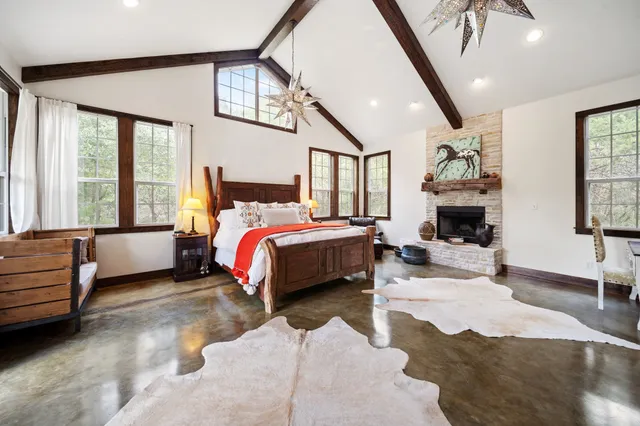 a spacious bedroom with a bed a mirror and desk