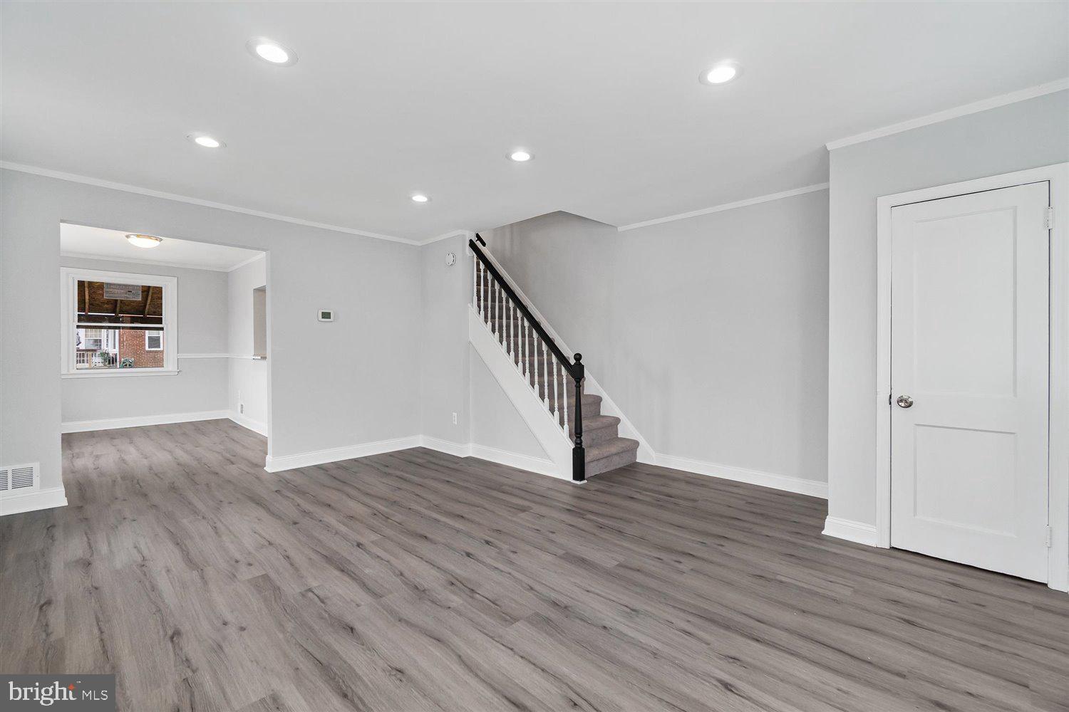 8419 Kavanagh Road Baltimore, MD 21222 - Photo 8 of 31 a view of an empty room with wooden floor and stairs