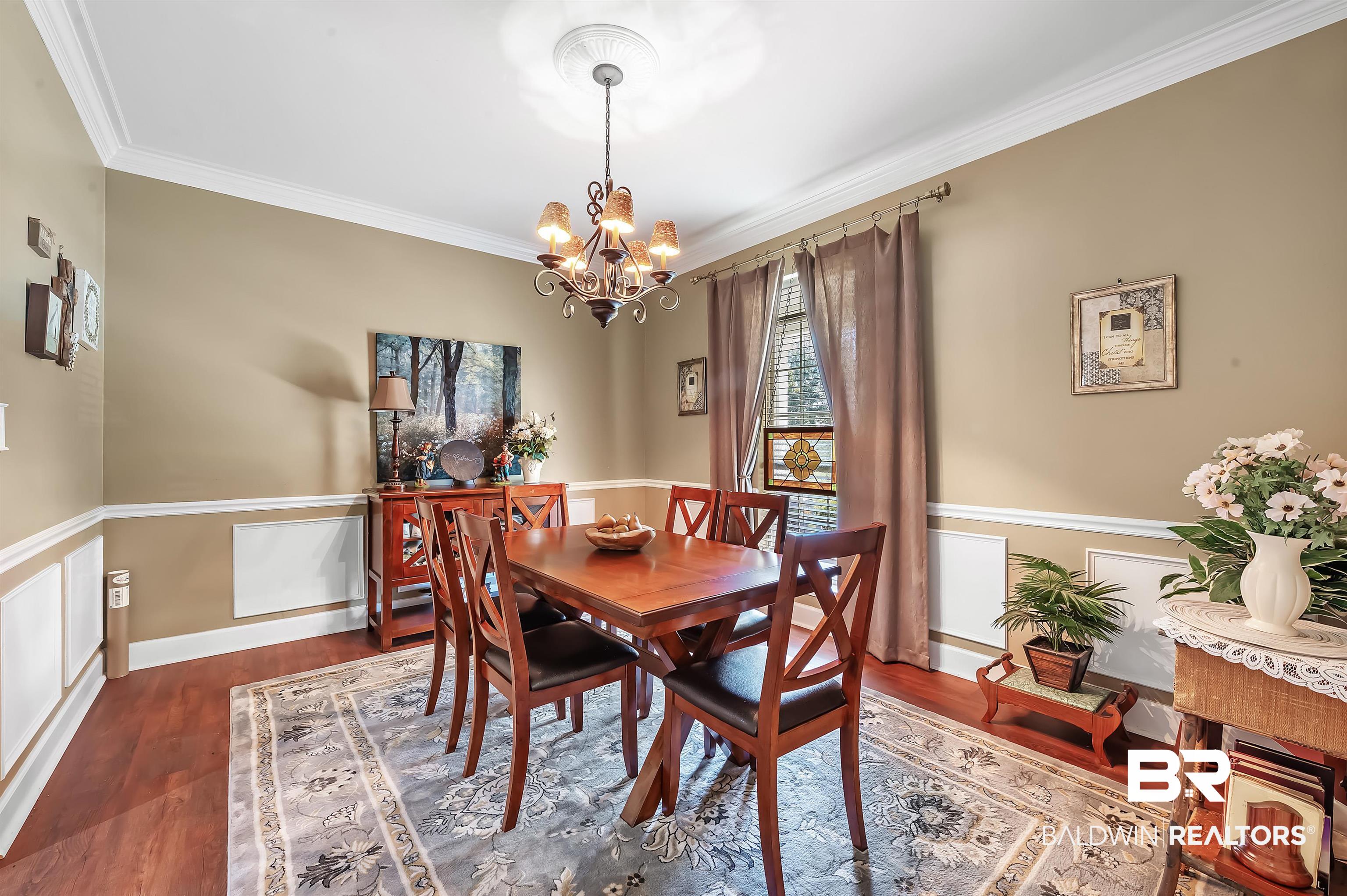 9901 Glover Court Fairhope, AL 36532 - Photo 10 of 52 Dining room with an inviting chandelier, crown molding, and dark wood-type flooring