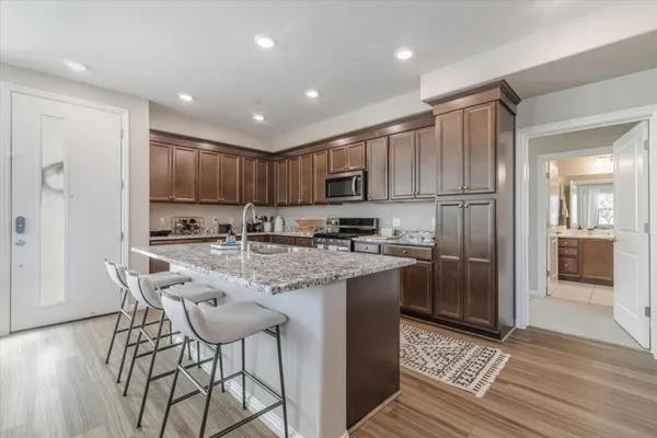a kitchen with kitchen island granite countertop wooden cabinets and refrigerator