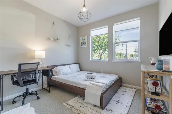 a bedroom with a bed a table and a flat screen tv
