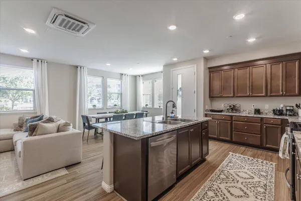 a kitchen with stainless steel appliances granite countertop a sink stove and cabinets