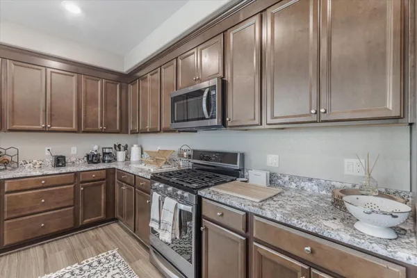 a kitchen with granite countertop cabinets stainless steel appliances and a sink