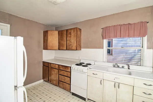 a kitchen with a sink cabinets and a refrigerator