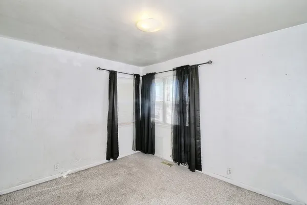 an empty room with closet and windows