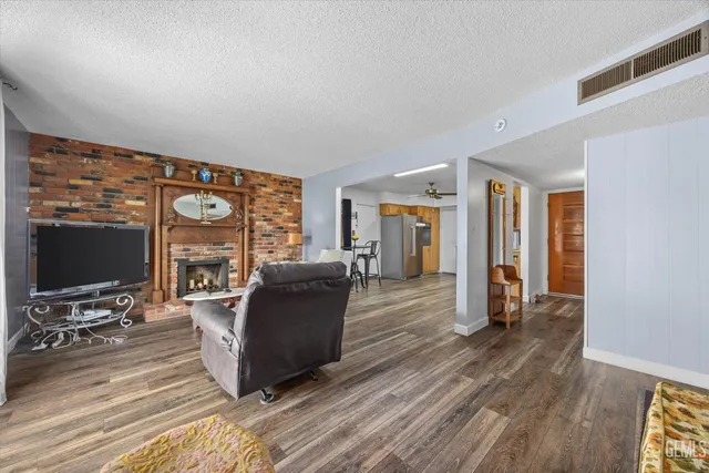 a living room with furniture a flat screen tv and wooden floor