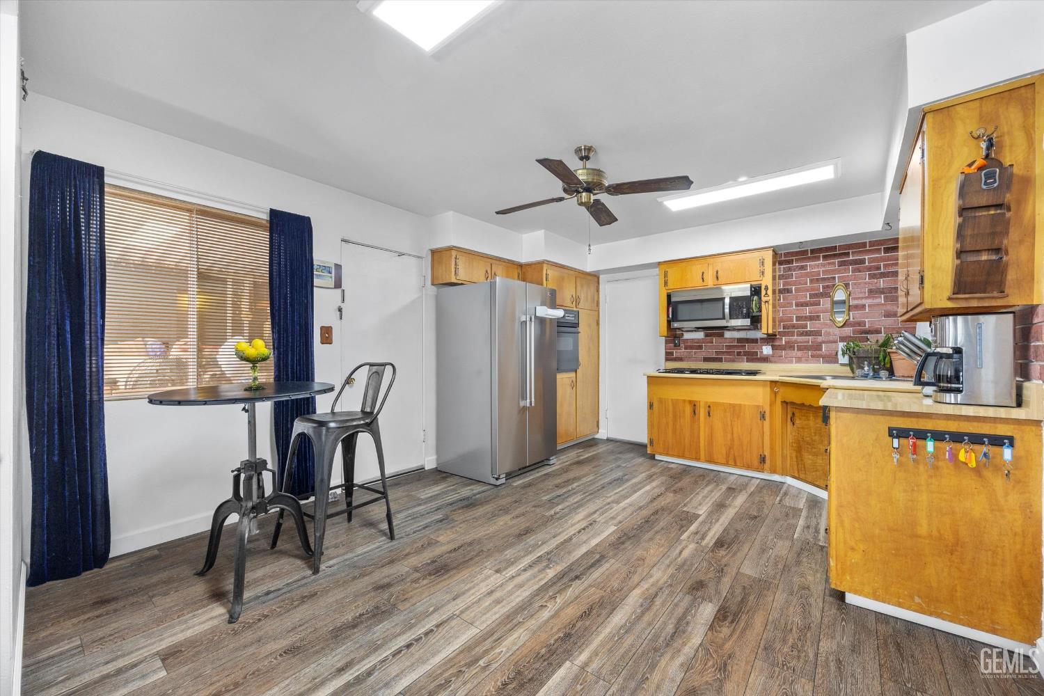 Undisclosed Address Taft, CA 93268 - Photo 24 of 42 a view of a kitchen with microwave and wooden floor
