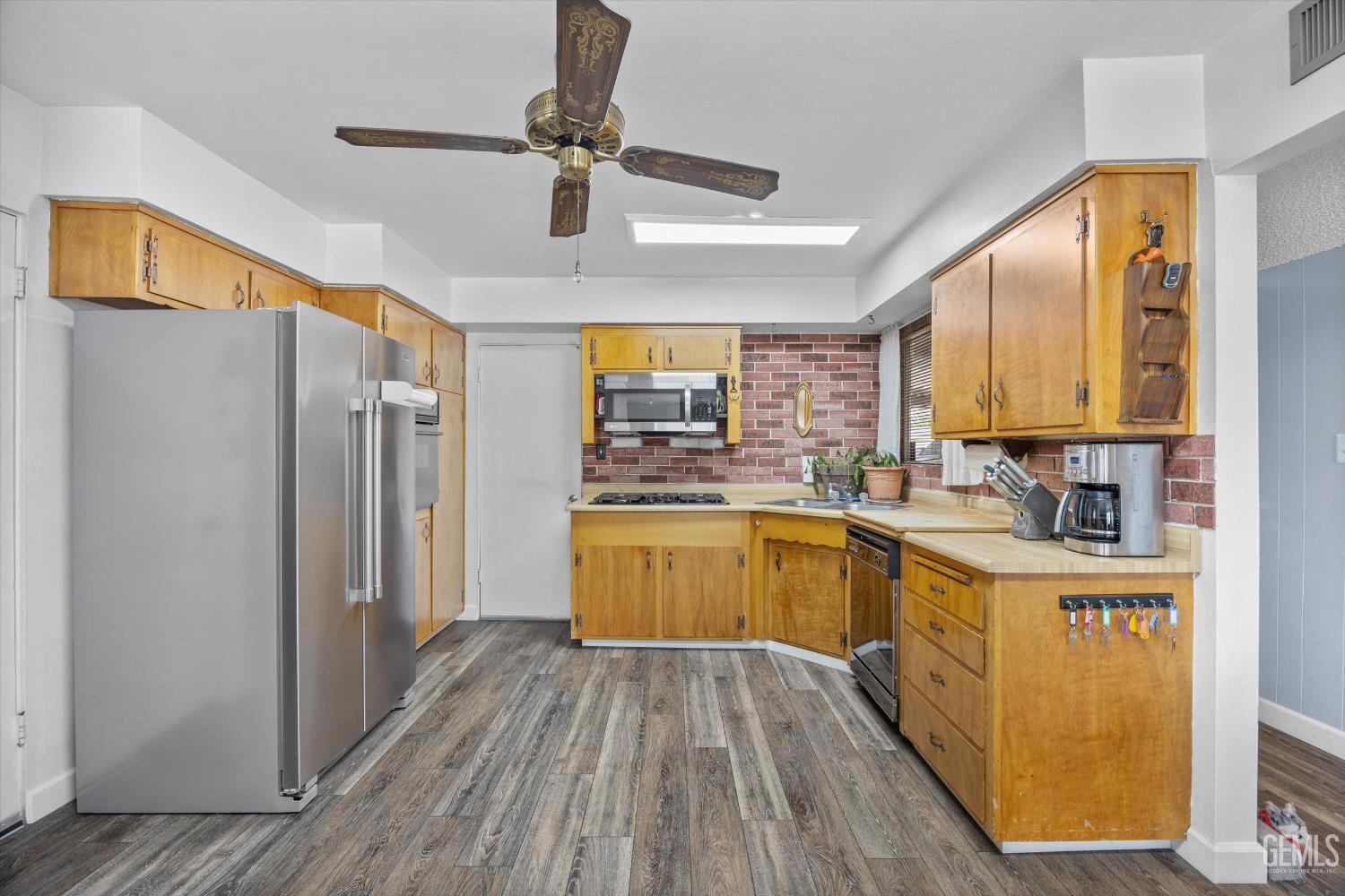 Undisclosed Address Taft, CA 93268 - Photo 27 of 42 a kitchen with stainless steel appliances granite countertop a refrigerator a sink dishwasher a stove and white countertops with wooden floor