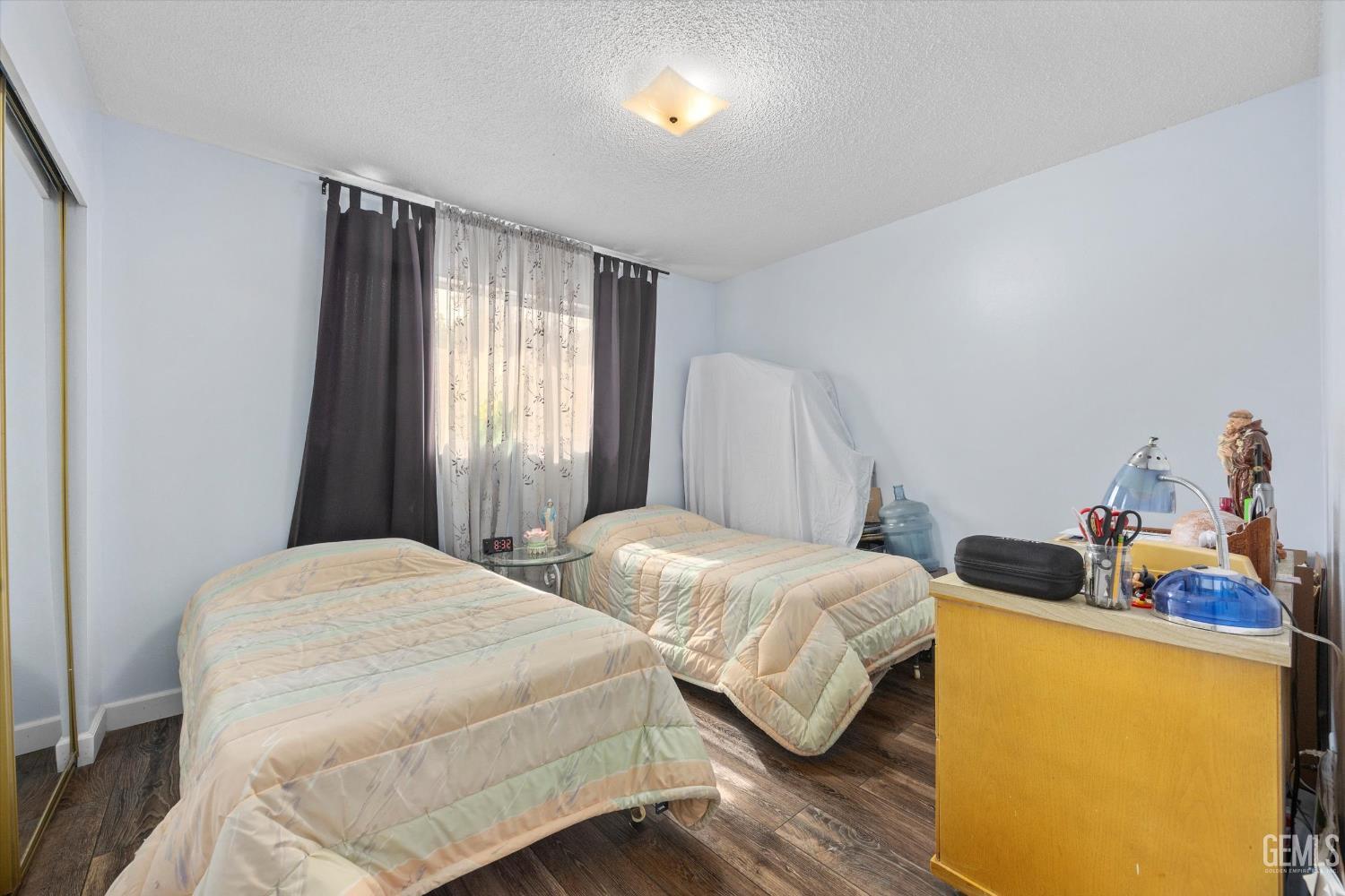 Undisclosed Address Taft, CA 93268 - Photo 36 of 42 a bedroom with two beds and a dresser with wooden floor