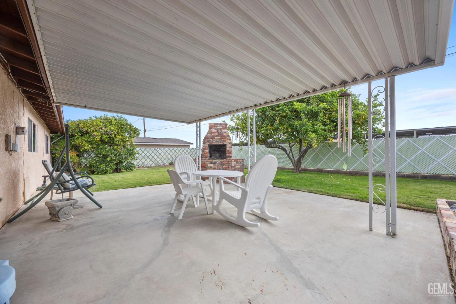 Undisclosed Address Taft, CA 93268 - Photo 37 of 42 a view of a patio with table and chairs under an umbrella with a small yard