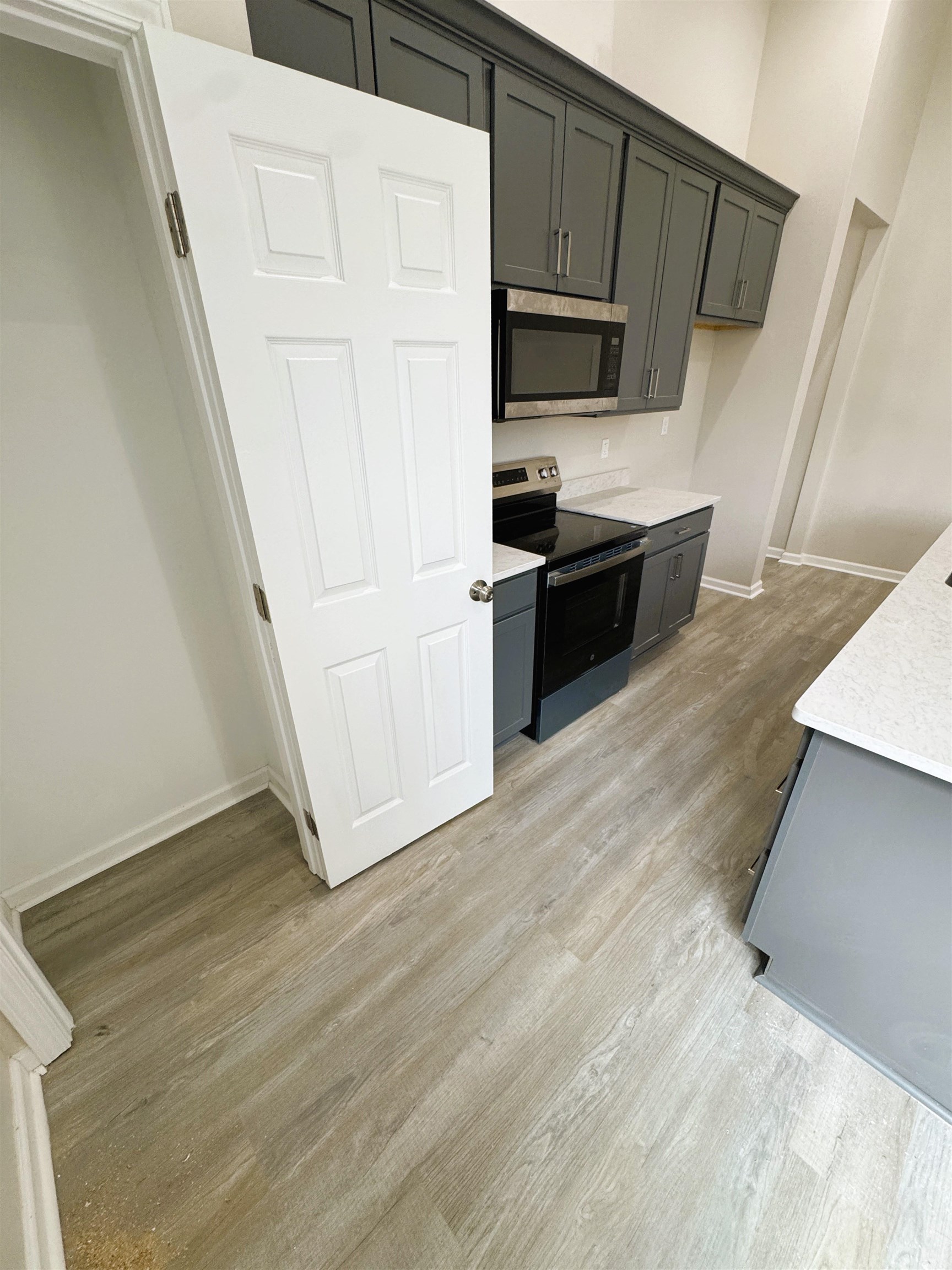 547 Berclair Road, Unit 101 Memphis, TN 38122 - Photo 7 of 19 Kitchen with stainless steel appliances, gray cabinetry, light stone counters, and light wood-style floors