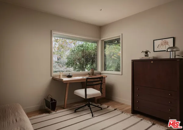 a view of a workspace with furniture and a window