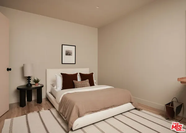 a bedroom with a bed and wooden floor
