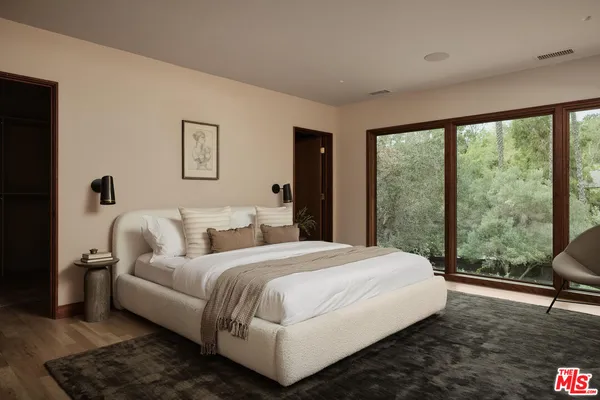 a bedroom with a bed and a large window