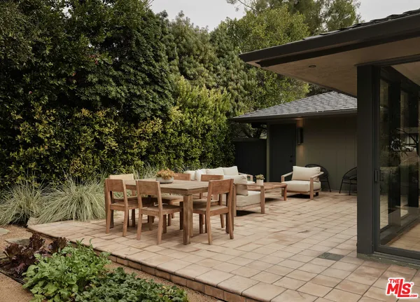 a patio with sofas fire pit table and chairs