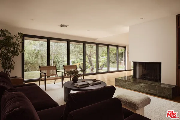 a living room with furniture and a floor to ceiling window
