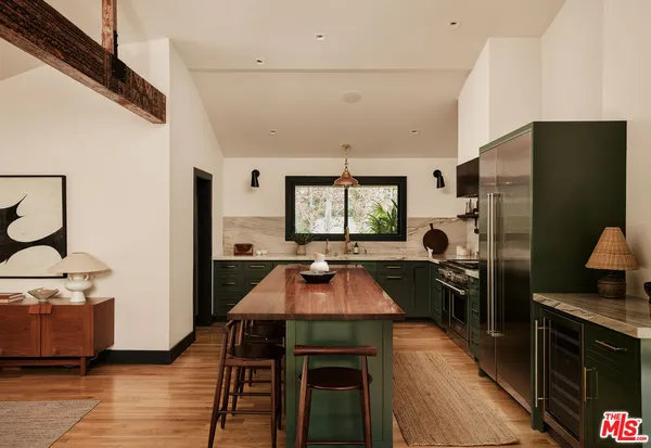a kitchen with a refrigerator and a stove top oven